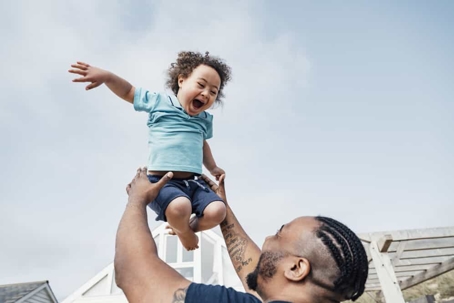 Father throws young child in the air and stays to catch him