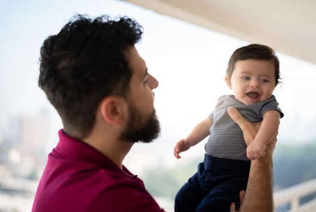 Father holds his young son in the air