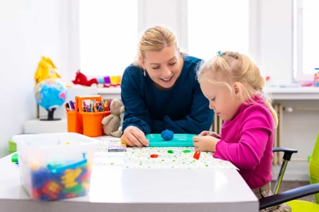 Mother plays with toys with her special needs daughter