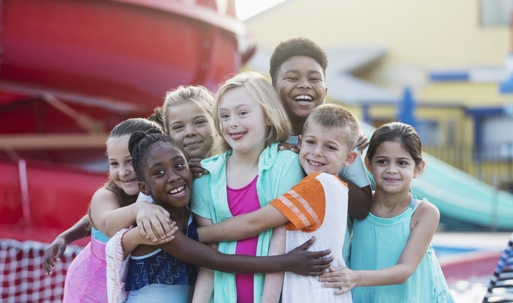 group of children hugging a girl with special needs