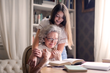 Young woman with arms around elderly woman